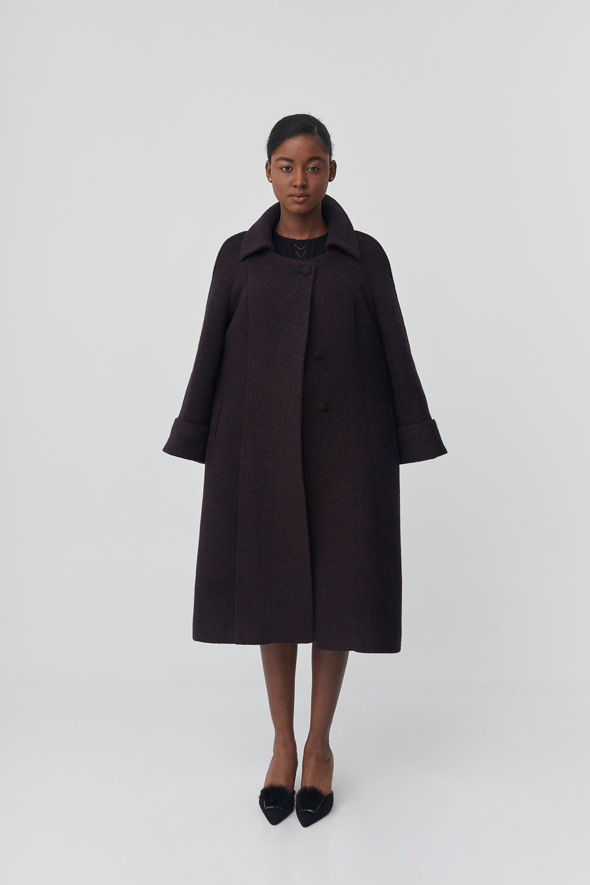 Person wearing a black coat on a white background