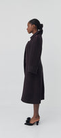 Person wearing a dark coat on a white background