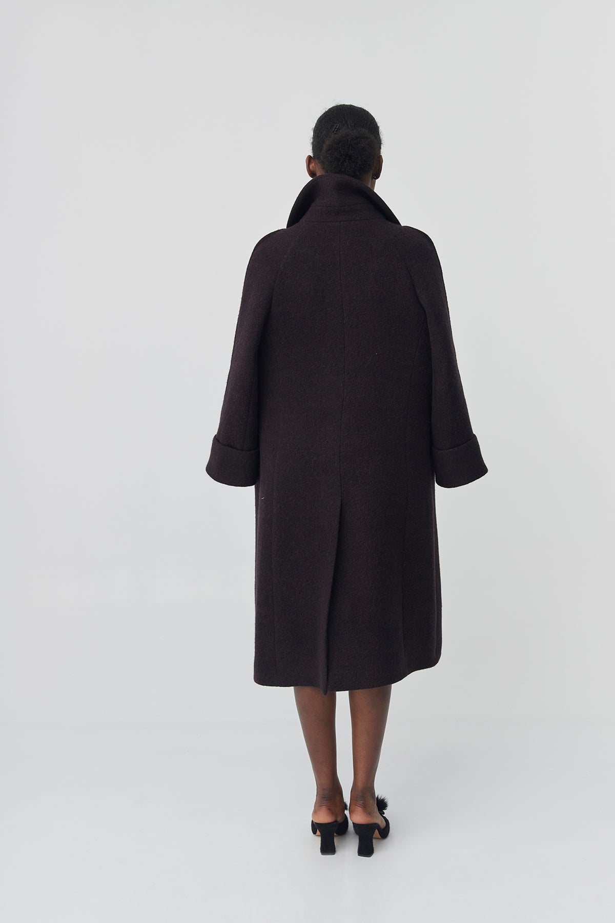 Person wearing a black coat on a white background