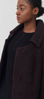 Woman wearing a dark coat on a white background