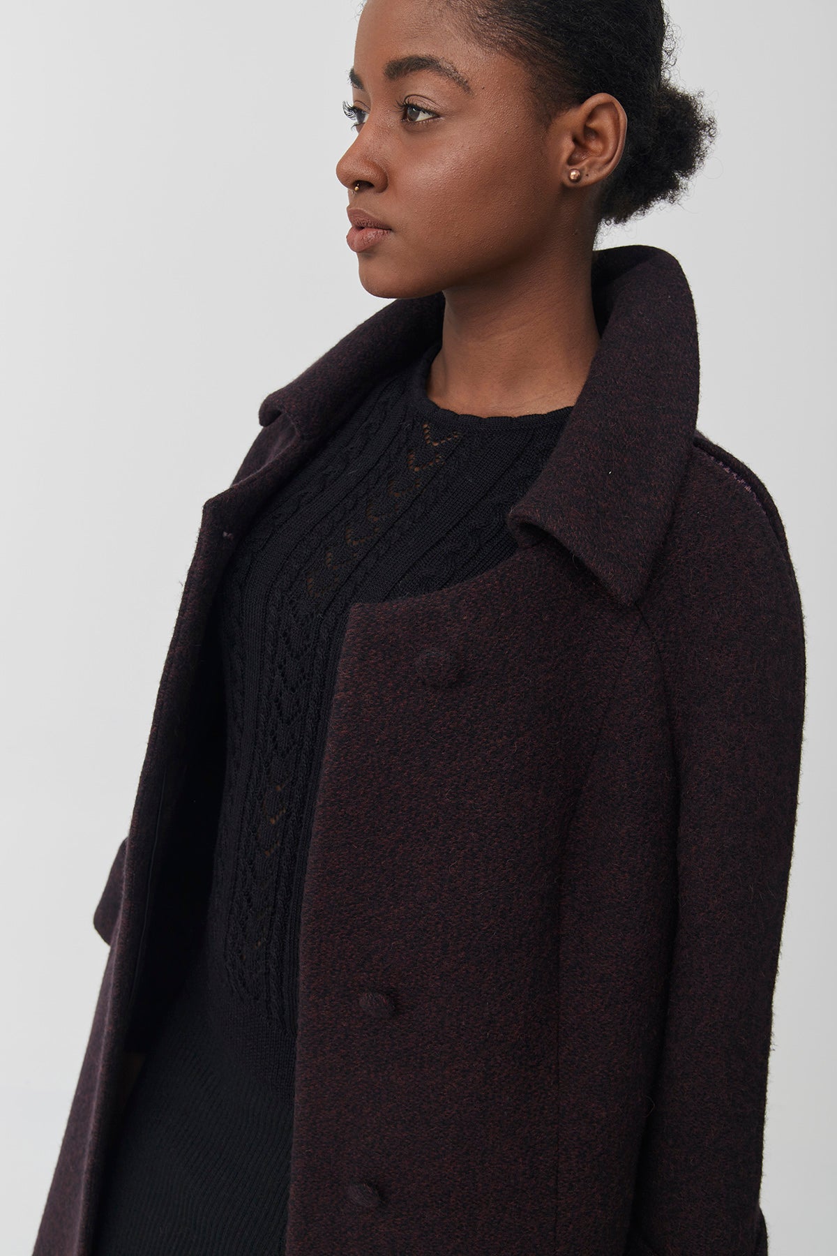 Woman wearing a dark coat on a white background