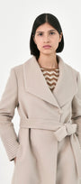 A model wearing a light beige baby alpaca belted coat 