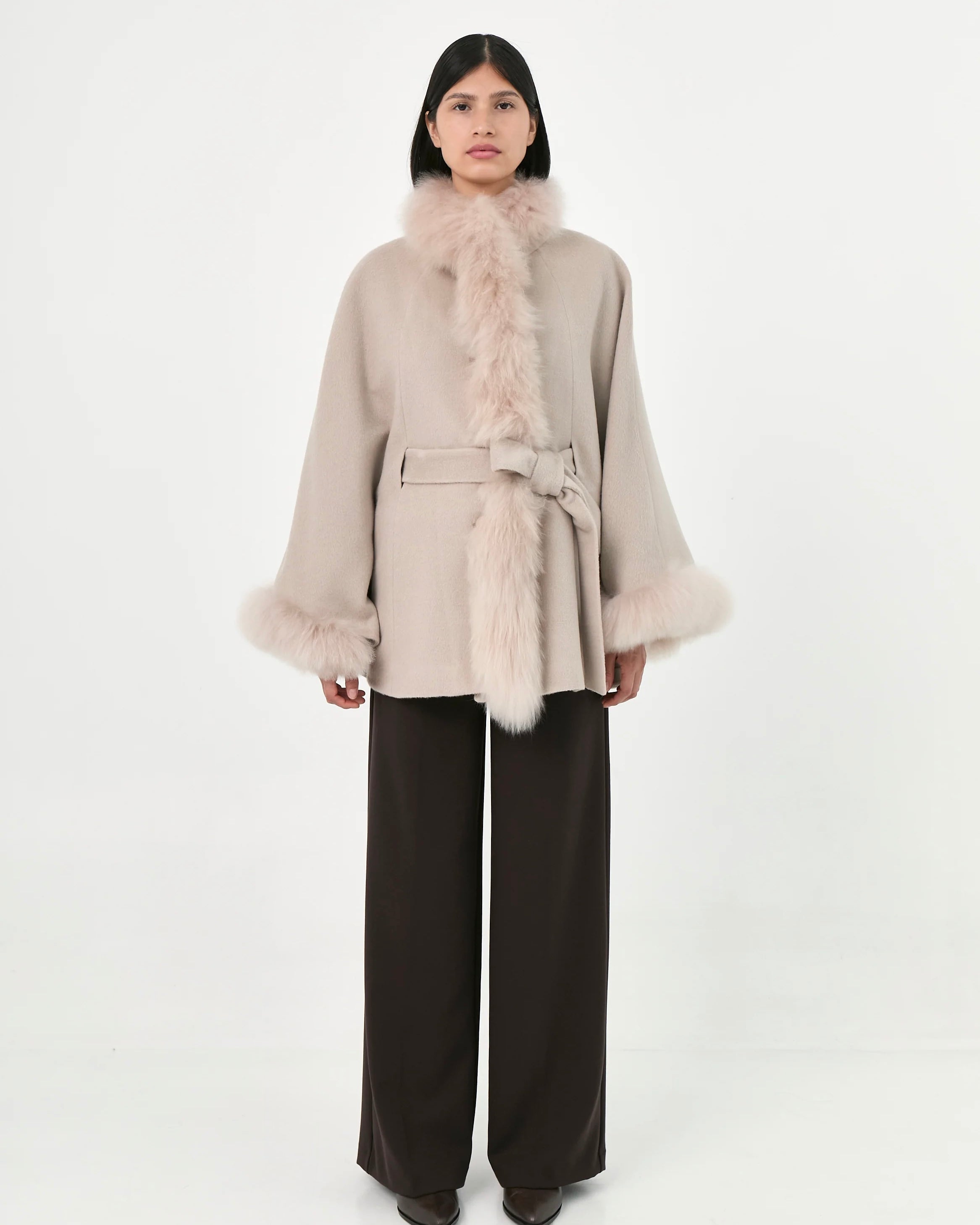 A model wearing a light beige Baby Alpaca belted Cape with fur.