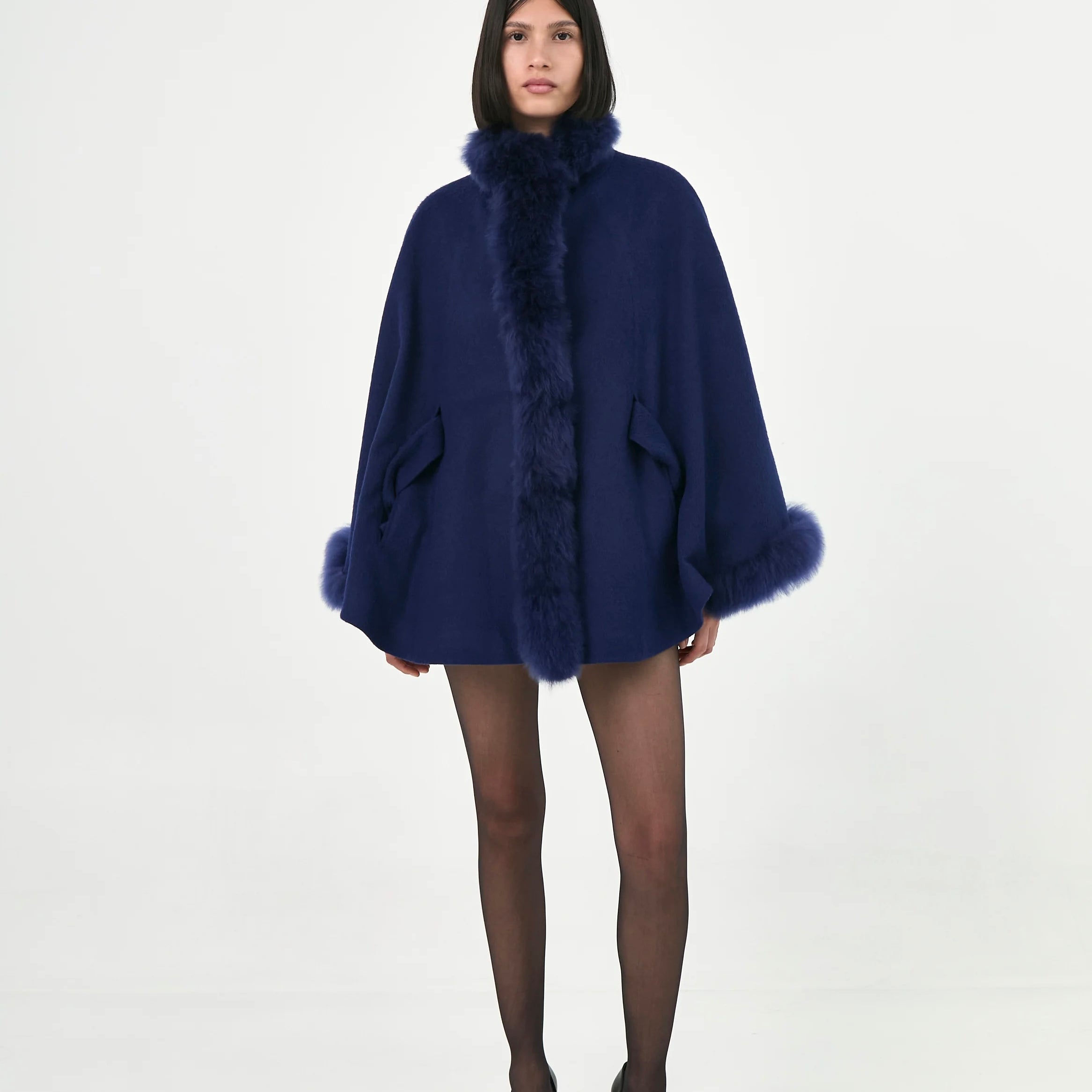 A model wearing a blue baby Alpaca belted Cape with fur.