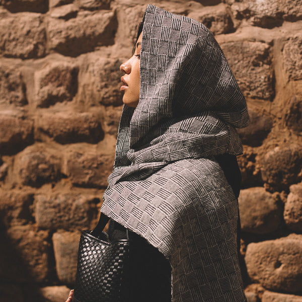 Person wearing a gray patterned shawl crafted in baby alpaca